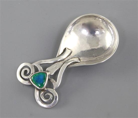 An Edwardian Arts & Crafts silver and enamel caddy spoon, Length 3 ¼”/86mm Width 1 ½”/40mm Weight: 1.2oz/33grms